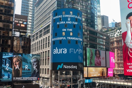 A novidade da união da Alura com a FIAP apareceu em diversos veículos da imprensa e também no telão da **Nasdaq** em Nova Iorque.