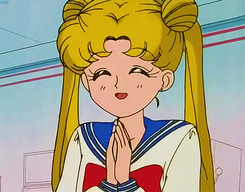 Sailor Moon, uma personagem de anime com longos cabelos loiros presos em duas partes, vestindo um uniforme de marinheiro com uma fita vermelha na parte superior. Ela está feliz e batendo palmas.
