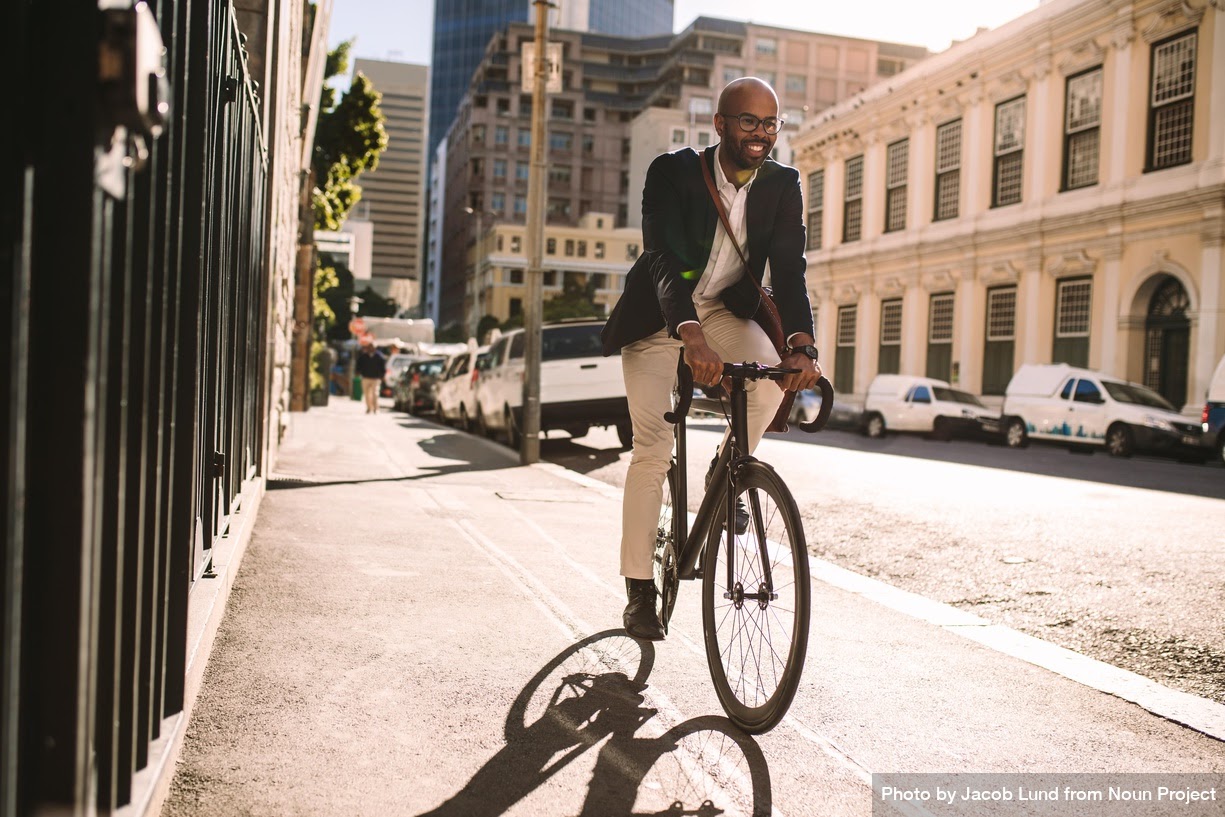 Homem andando de bicicleta na calçada. #inset