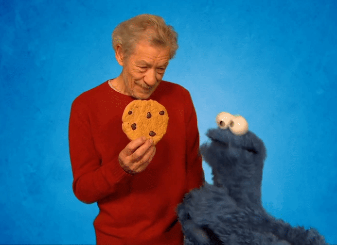 O arquivo gif apresenta o ator Ian Murray McKellen, um senhor de 83 anos, pele clara e cabelos brancos. Ele está com uma blusa vermelha de manga comprida e segura um biscoito Cookie que possui a mesma proporção de sua mão aberta. Ao seu lado está o personagem Cookie Monster, um fantoche peludo e azul com os olhos bem evidentes. O personagem Cookie Monster vai em direção ao Cookie e o ator Ian McKellen levanta sua mão esquerda aberta , interrompendo a ação do Cookie Monster de pegar o biscoito.