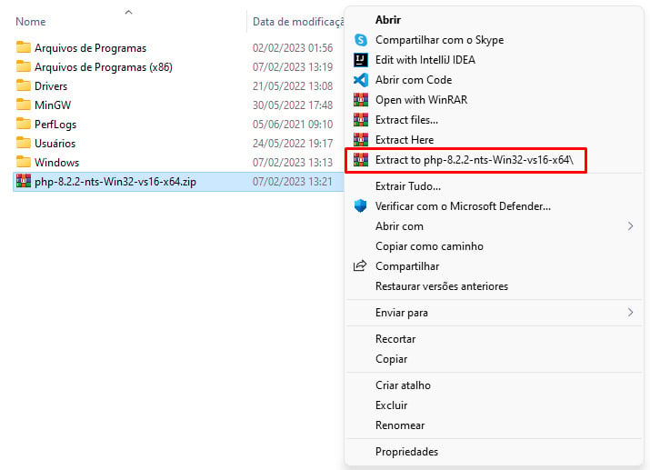 Imagem do mesmo print anterior, que mostra a tela do Disco Local (C:), com destaque para o arquivo compactado “php-8.2.2-nts-Win32-vs16-x64”. A imagem mostra a seleção deste arquivo. Ao clicar com o botão direito do mouse, é mostrada uma aba com opções. Em destaque vermelho, há a opção que devemos clicar “Extract to php-8.2.2-nts-Win32-vs16-x64”.