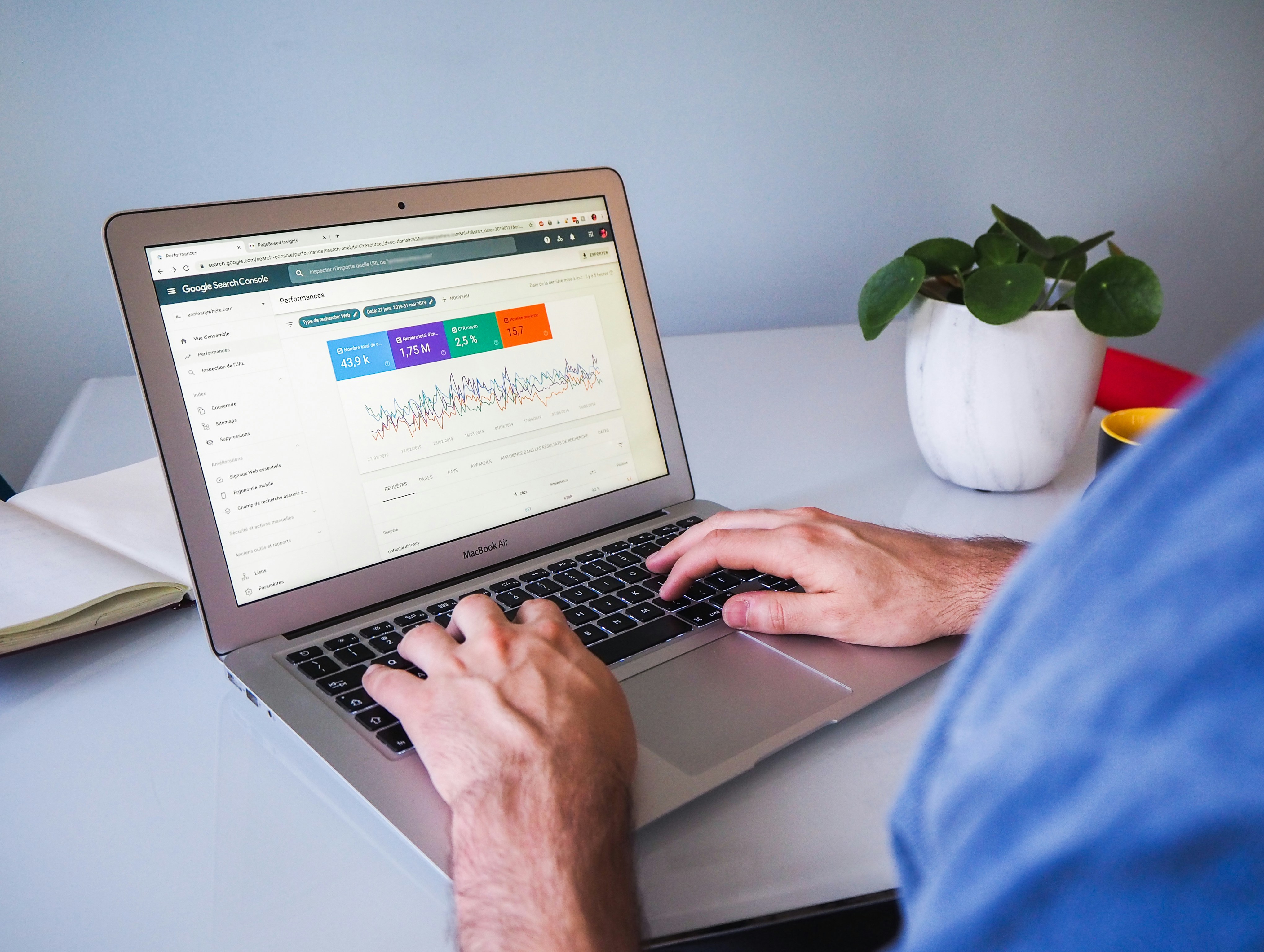 Foto de um profissional de marketing digital trabalhando em um computador portátil, com a ferramenta Google Search Console aberta na tela, exibindo gráficos e métricas de SEO.