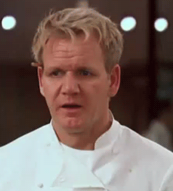 A imagem em loop mostra um homem caucasiano com uma blusa branca de chef de cozinha. Ele está apoiando um lápis com a orelha direita e olha incrédulo para alguma coisa.