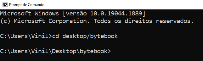 Imagem do prompt de comando do windows, com fundo preto. Na linha de comando, estamos navegando até a pasta “bytebook” que está localizada na área de trabalho.