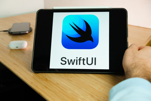 Imagem que apresenta um tablet inclinado no qual se vê o símbolo da linguagem Swift, a silhueta de uma ave na cor preta, e logo abaixo está escrito Swift UI.