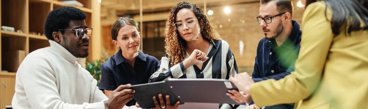 pessoas reunidas em uma empresa, olhando para o resultado de um projeto, em representação aos erros no desenvolvimento de pessoas