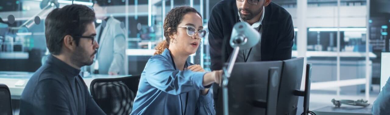 3 pessoas em frente a um computador representando a gestão da informação